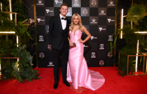 Zane Duursma of North Melbourne with partner Siena Tainsh. Corset-style bodices are proving popular tonight.  (AAP: Joel Carrett)